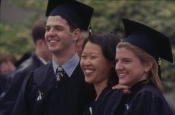 Three graduates smile together for a photograph