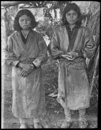 Two Ainu girls with mouth tattoos outside chise