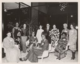 Group photo of women in different cultural styles of dress and one man