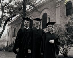Three students stand outside on Commencement day